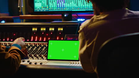 artista y diseñador de sonido examinan el software de edición digital y la maqueta en la tableta
