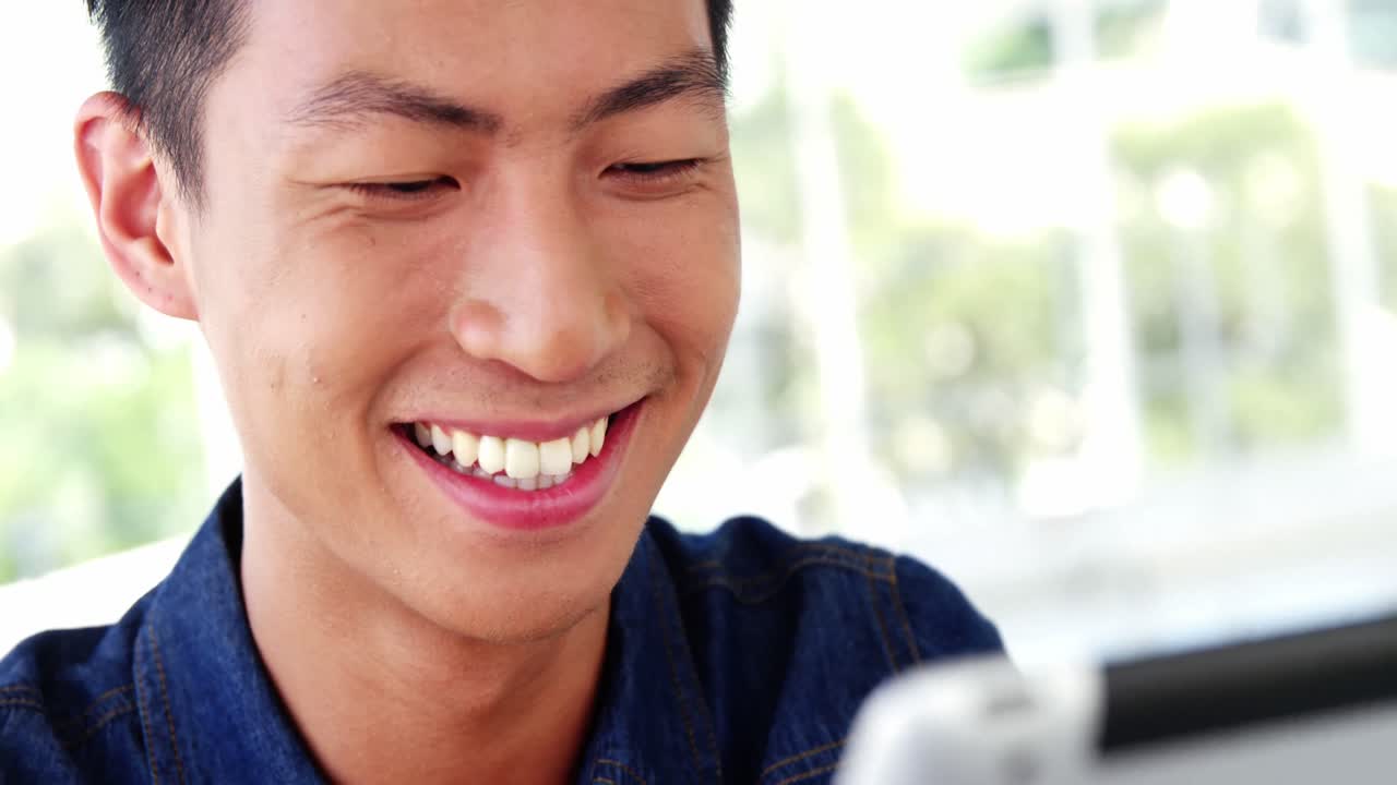 웃는 남자가 똑똑한 장치를 보고 있다