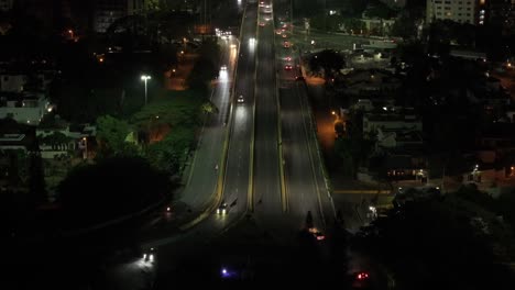 Night-Traffic-in-Santo-Domingo,-Dominican-Republic,-Aerial-View-of-Avenue-and-Car-Lights-in-Residential-Suburbs