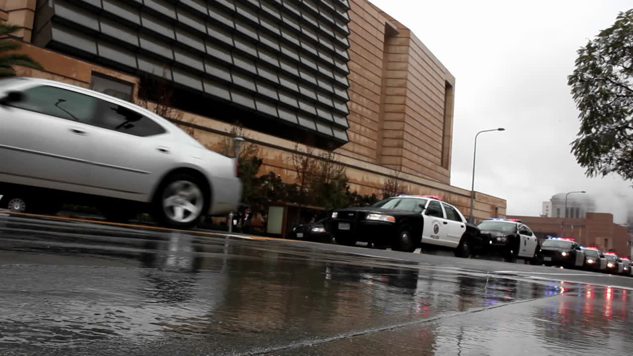 비오는 날 길을 따라 경찰차들이 지나가고 있다