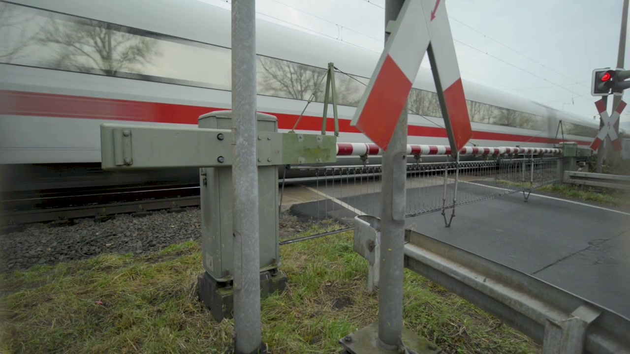 Pociąg dużych prędkości przejeżdża przez przejazd kolejowy w pochmurny dzień, zbliżenie