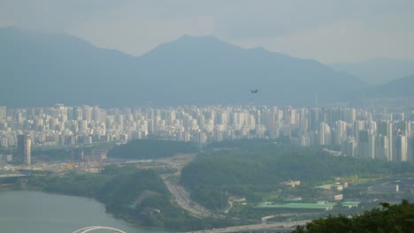 보잉 ch-47 치누크 화물 헬리콥터가 흐릿한 날 서울 상공을 비행하며 아차산 정상 공중에서 전망을 감상할 수 있습니다.