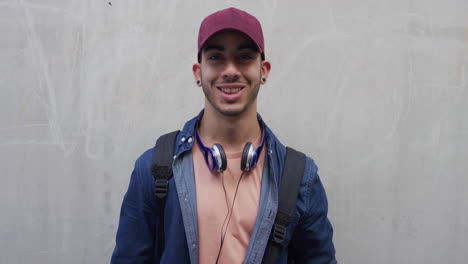 portrait attractive young hispanic teenage man smiling happy enjoying successful lifestyle male student looking confident wearing hat slow motion