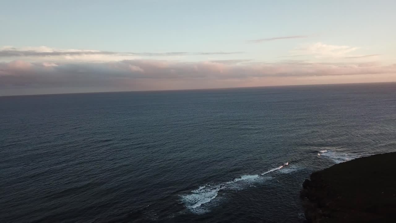 Panoramica con drone di montagna con arcobaleno, oceano e spiaggia al tramonto a Kauai, Hawaii.