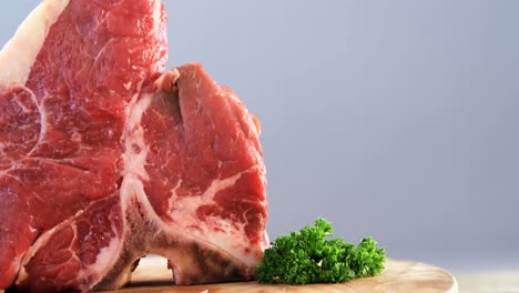 carne cruda y perejil en una mesa de madera