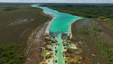 aerial view over the rapidos de bacalar, in sunny mexico - tilt, drone shot