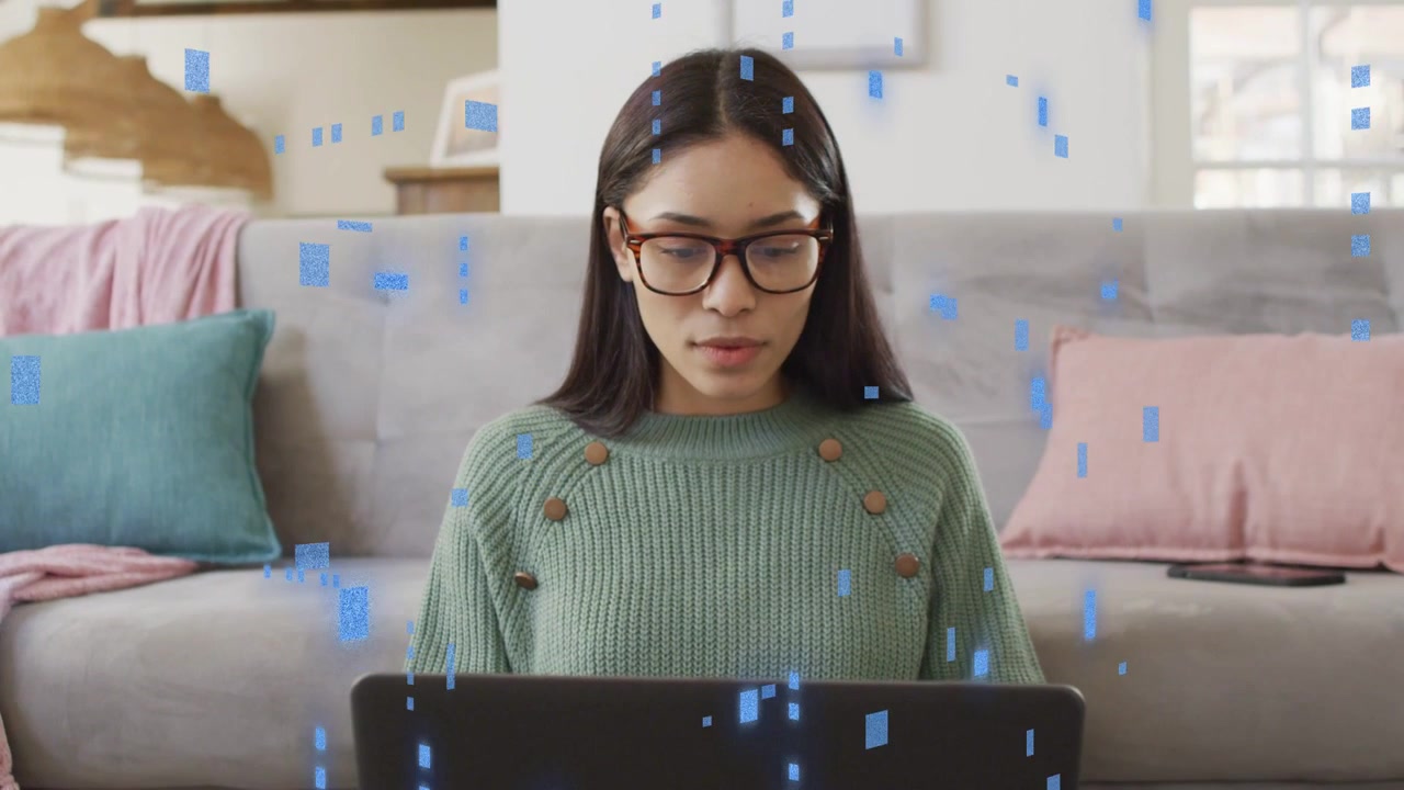 Woman using laptop at home for education reading screen then typing while blue data squares flowing