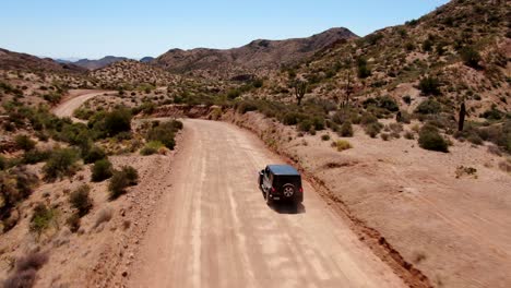 4k drone road trip driving down dusty road in arizona