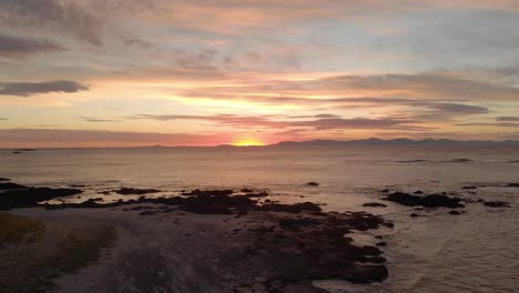 Aerial-shot-rising-up-over-a-beach-in-southern-Victoria-with-a-beautiful-early-morning-sunrise