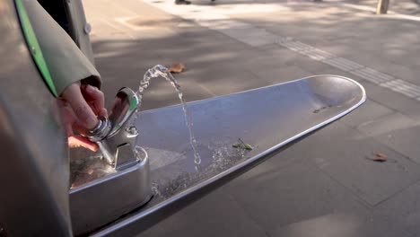 presionando el grifo con la mano, el agua fluye en melbourne