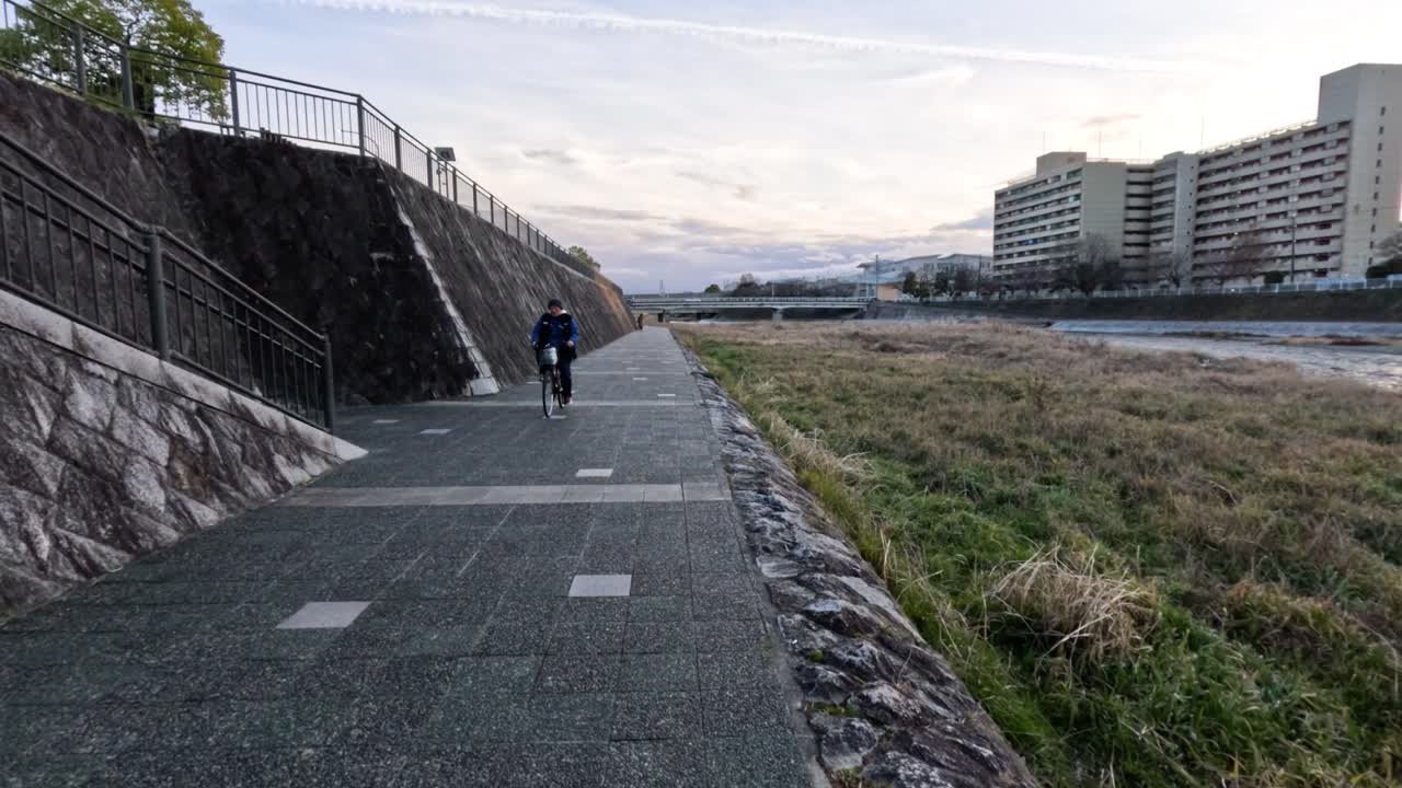 경치 좋은 강변 길 을 따라 자전거 타는 사람