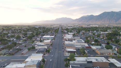 Luftbild-Von-Autos,-Die-In-Der-Stadtstraße-Von-Spanish-Fork-Mit-Bergblick-Bei-Sonnenuntergang-In-Utah,-Usa,-Fahren