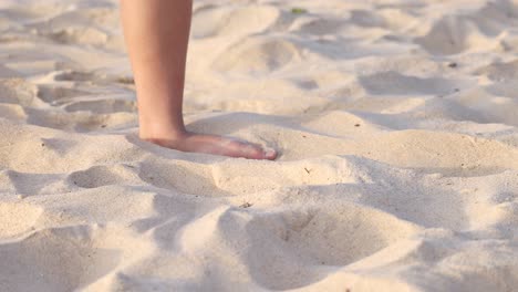 person kicking sand barefoot on karon beach, phuket, thailand