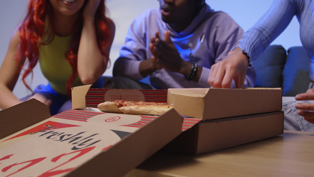 소파에 앉아있는 젊은 gen z 친구들의 스튜디오  홈 배달 테이크아웨이 피자 1