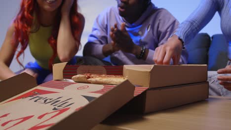 fotografía de estudio de jóvenes amigos de la generación z sentados en el sofá con pizza para llevar a casa 1