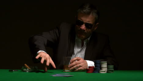 angry gambler folding his hand of poker