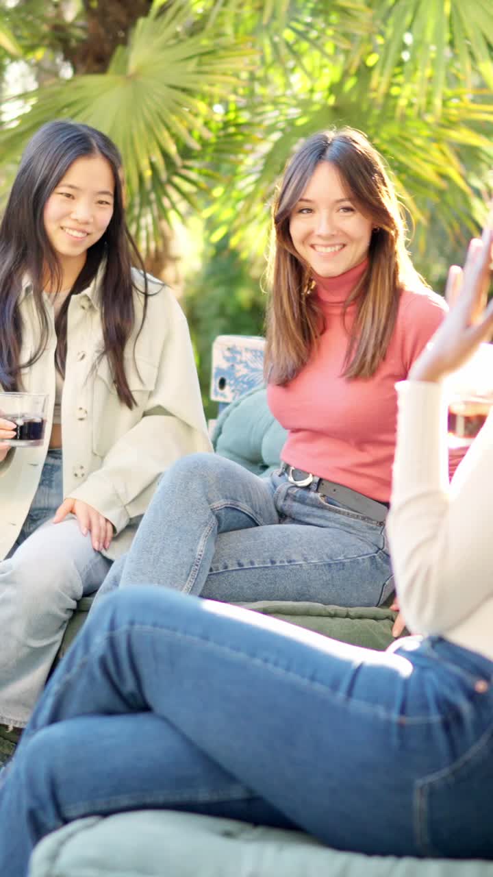 Multi-ethnic friends chatting on a garden in sunset