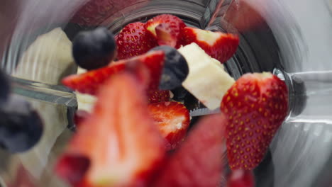 closeup berries dropped blender in super slow motion. healthy nutrition concept.