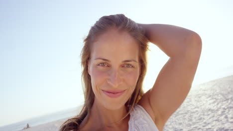 hermosa mujer tomando una selfie usando el teléfono en la playa al atardecer sonriendo y girando en vacaciones