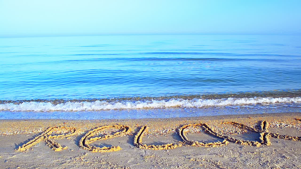 Kumda "relax" yazısı. Kumda yazı, plaj