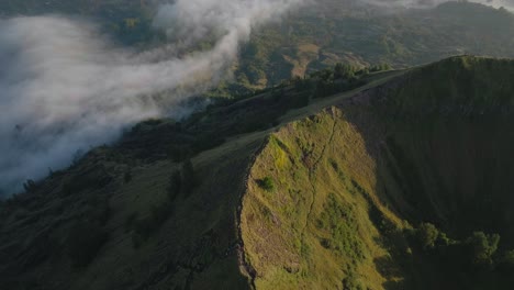 mount batur ridge with hiking trail visible during sunrise, aerial