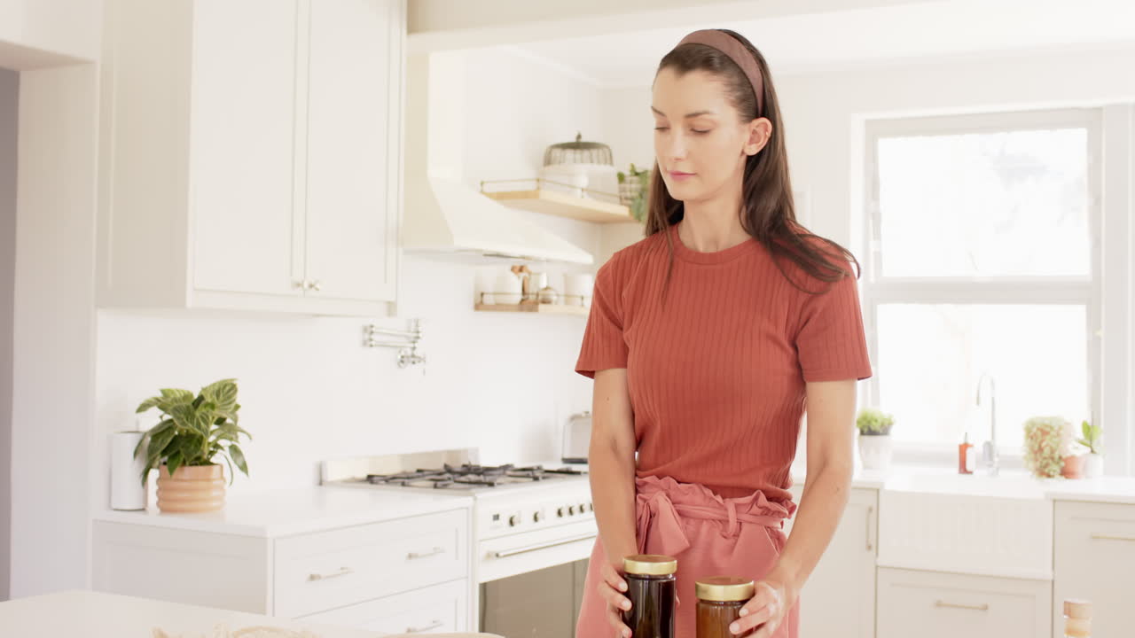 Giovane donna che prepara ingredienti freschi in una cucina moderna, concentrandosi sulla cucina.