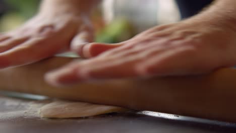 a person flattens dough on a table top