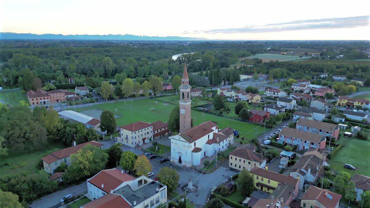 Aerial View Flying Beside Church Bell Tower in Small Italian Town At Golden Hour