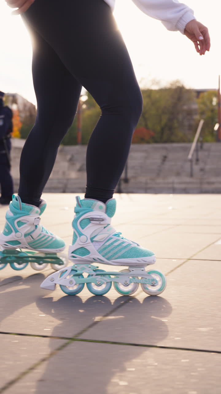 A low-angle vertical shot of a rollerblader practicing their inline skating routine on a paved park path. Captures an active lifestyle and the aesthetic of urban skating during a sunny day