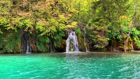 pan right view of small waterfalls flowing in turquoise water of lake in plitvice national park