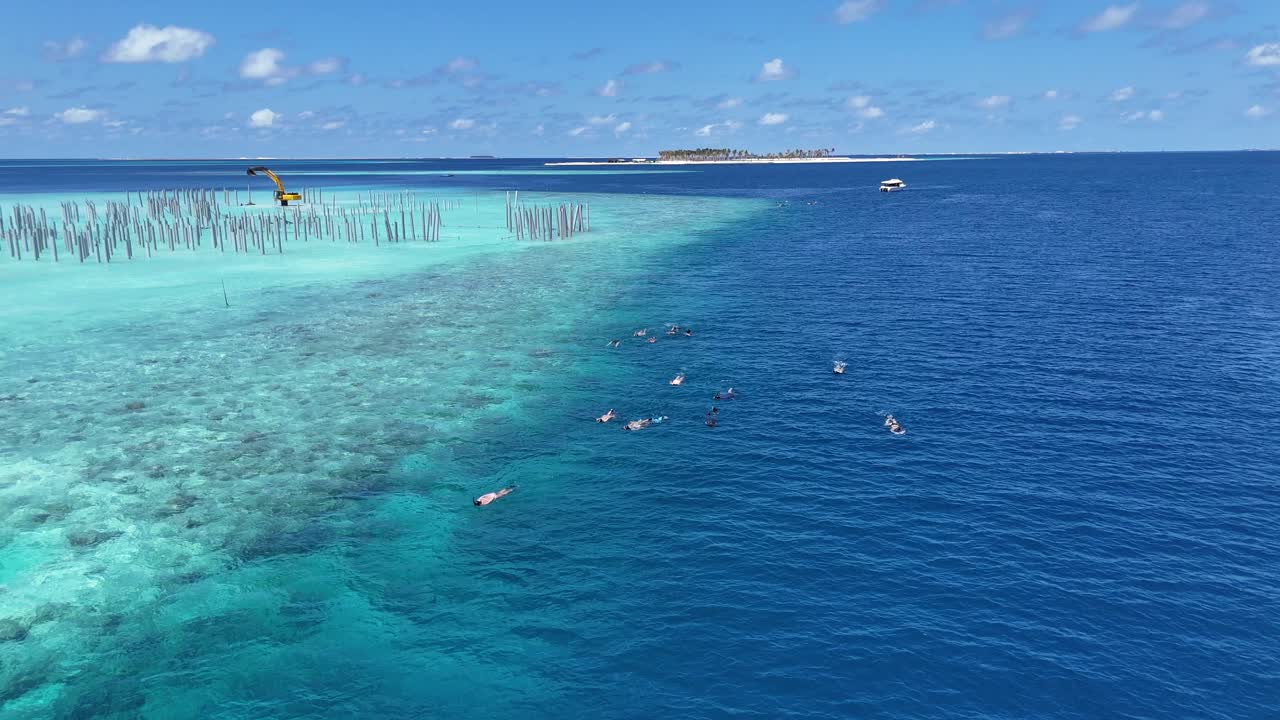 Luftfoto af afsidesliggende maldivisk ø omgivet af dybblåt ocean