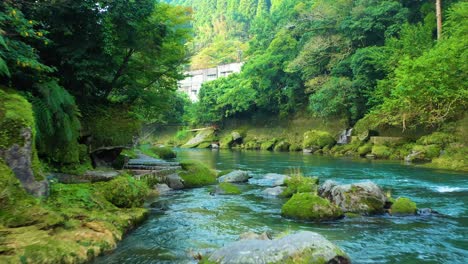 Scenic-aerial-over-Kirishima-river-surrounded-by-lush