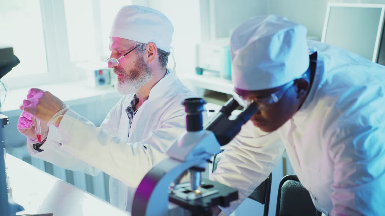 Due scienziati che lavorano in un moderno laboratorio con microscopi e proiettili