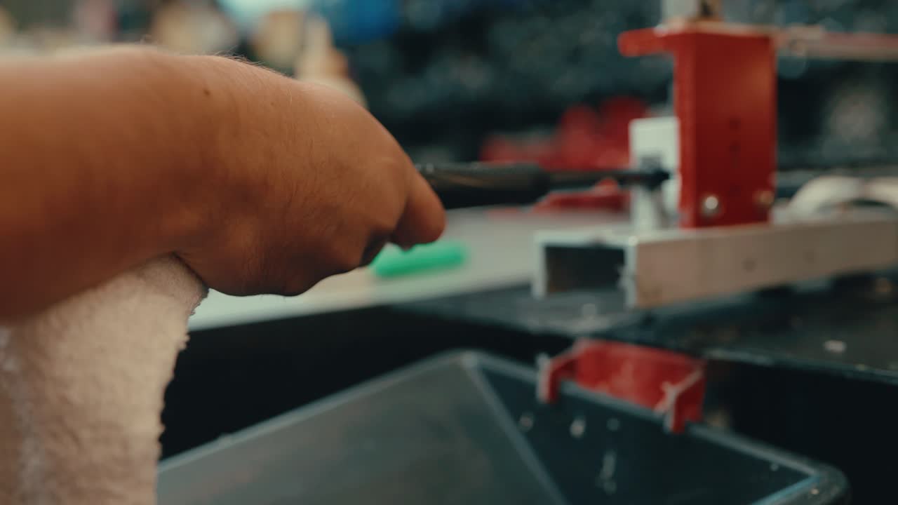 Caucasian male hands push and slide grip onto golf club shaft with water droplets dripping as vice holds club still for custom fitting in workshop in slow motion
