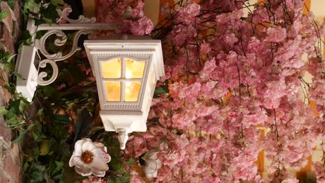 white lantern hanging among pink cherry blossoms