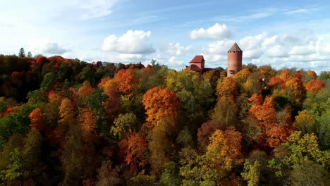 reenvío aéreo sobre un castillo medieval de turaida, sigulda en la región de vidzeme de letonia rodeada de un colorido bosque otoñal al atardecer