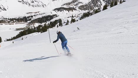 female skier skiing downhill on a steep ski slope in the austrian mountains