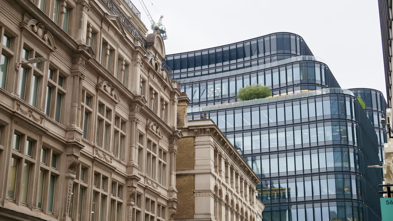 Contrast view of traditional Victorian-style buildings alongside sleek, modern glass office blocks in London, England