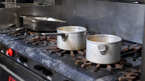 dirty pots and pans on a commercial kitchen stove