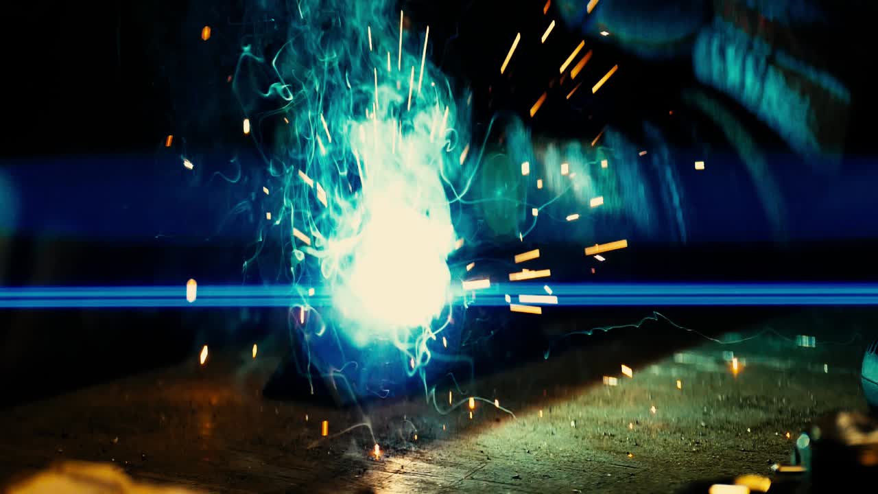 금속 용접공은 보호 장비를 갖춘 공장에서 강철 용접공과 함께 일합니다