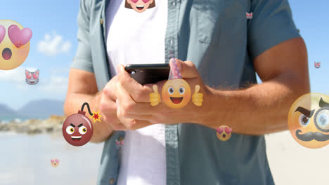 Animation-Von-Emoticons-über-Dem-Mittelteil-Eines-Kaukasischen-Mannes,-Der-Im-Freien-Sein-Smartphone-Benutzt