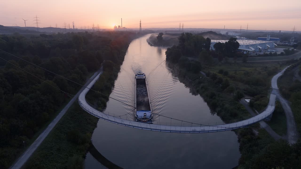 Sunrise over Industrial Canal with Barge and Bridge