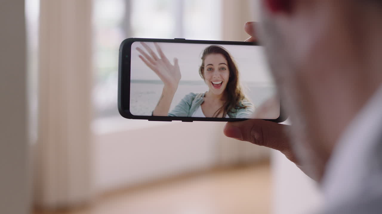 hombre joven chateando en video con su novia en el teléfono inteligente saludando con la mano mujer joven compartiendo vacaciones viaje pareja teniendo una relación a larga distancia