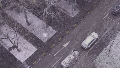 Caída-De-Nieve-En-Una-Calle-Con-Autos-Estacionados-Al-Costado-De-La-Carretera.