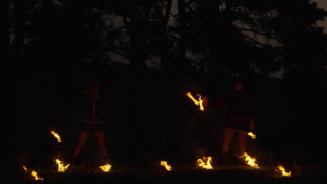 fire dancers in the forest at night
