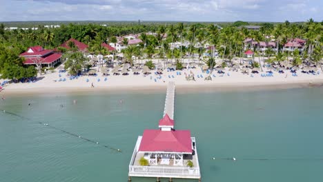 drone pov flying over long pier and gazebo of bahia principe hotel and resort at la romana, dominican republic