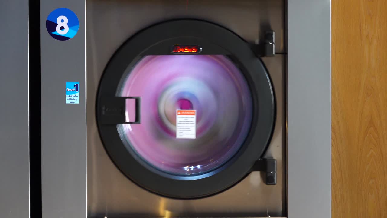 lavadora industrial lavando ropa. máquina de lavar trabajando. lavadora grande, puerta de vidrio transparente está girando tambor con lavadora, servicio de lavandería de la industria