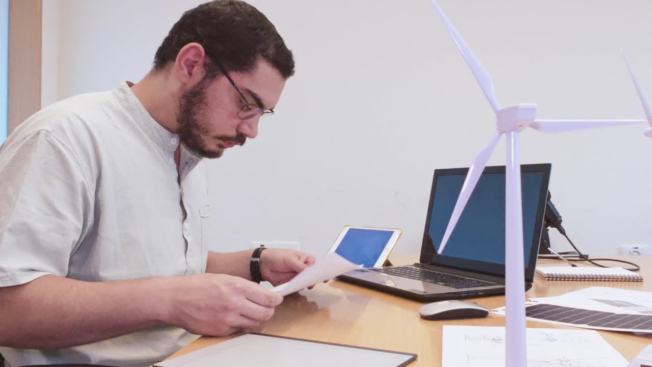 Young Designer Organizing Technical Drawings for a Green Energy Project