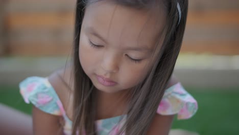 una madre y su hija pequeña se sientan en una manta en el patio trasero, participando en una actividad de dibujo juntos. la escena al aire libre captura un momento familiar pacífico, fomentando la creatividad y el vínculo.