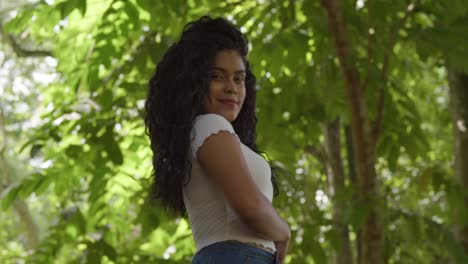 increíble vista de ángulo bajo de un modelo de pelo rizado en un entorno de parque en un día soleado